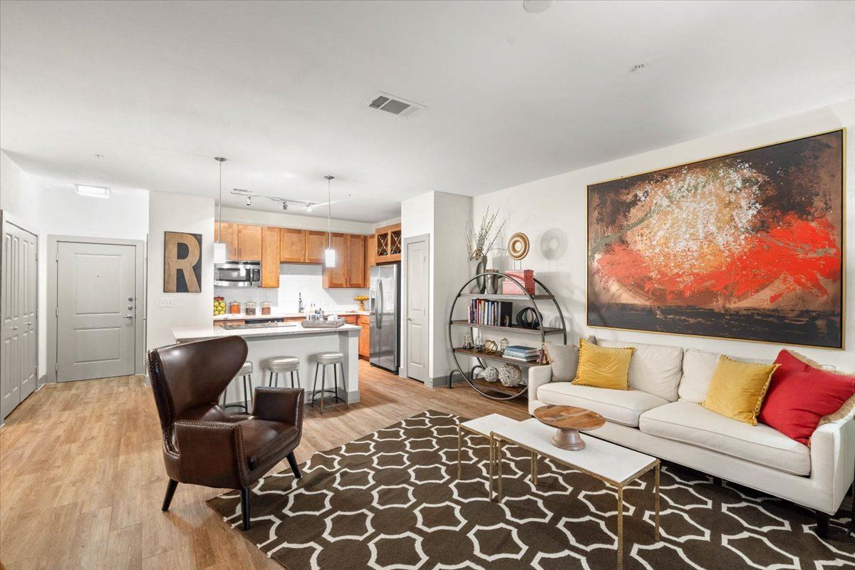 a living room and kitchen with a couch and chair